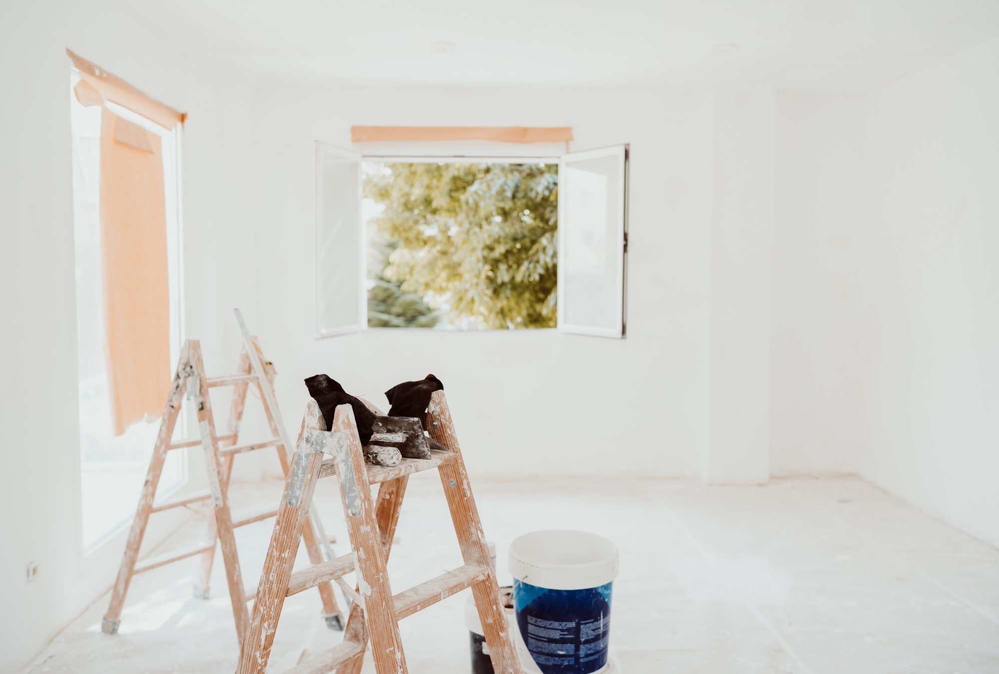 ladders and painter tools on white room at construction site. Painting walls. Home improvement ladders and painter tools on white room at construction site. Painting walls. Home improvement